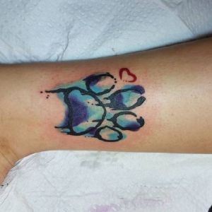 tatuaje de huella de perro pierna