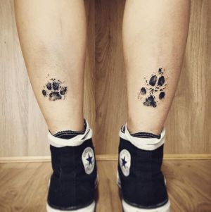 tatuajes de huellas de perros en las piernas