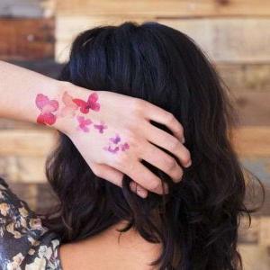 tatuaje acuarela de mariposa en la mano