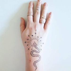 serpiente tatuada en la mano